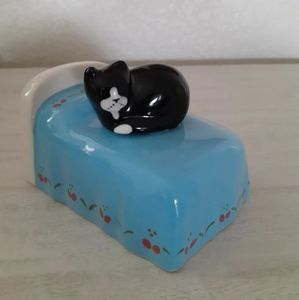 Katz & Co Black and white cat on blue bed